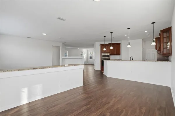 a large white kitchen with a large counter top space and stainless steel appliances