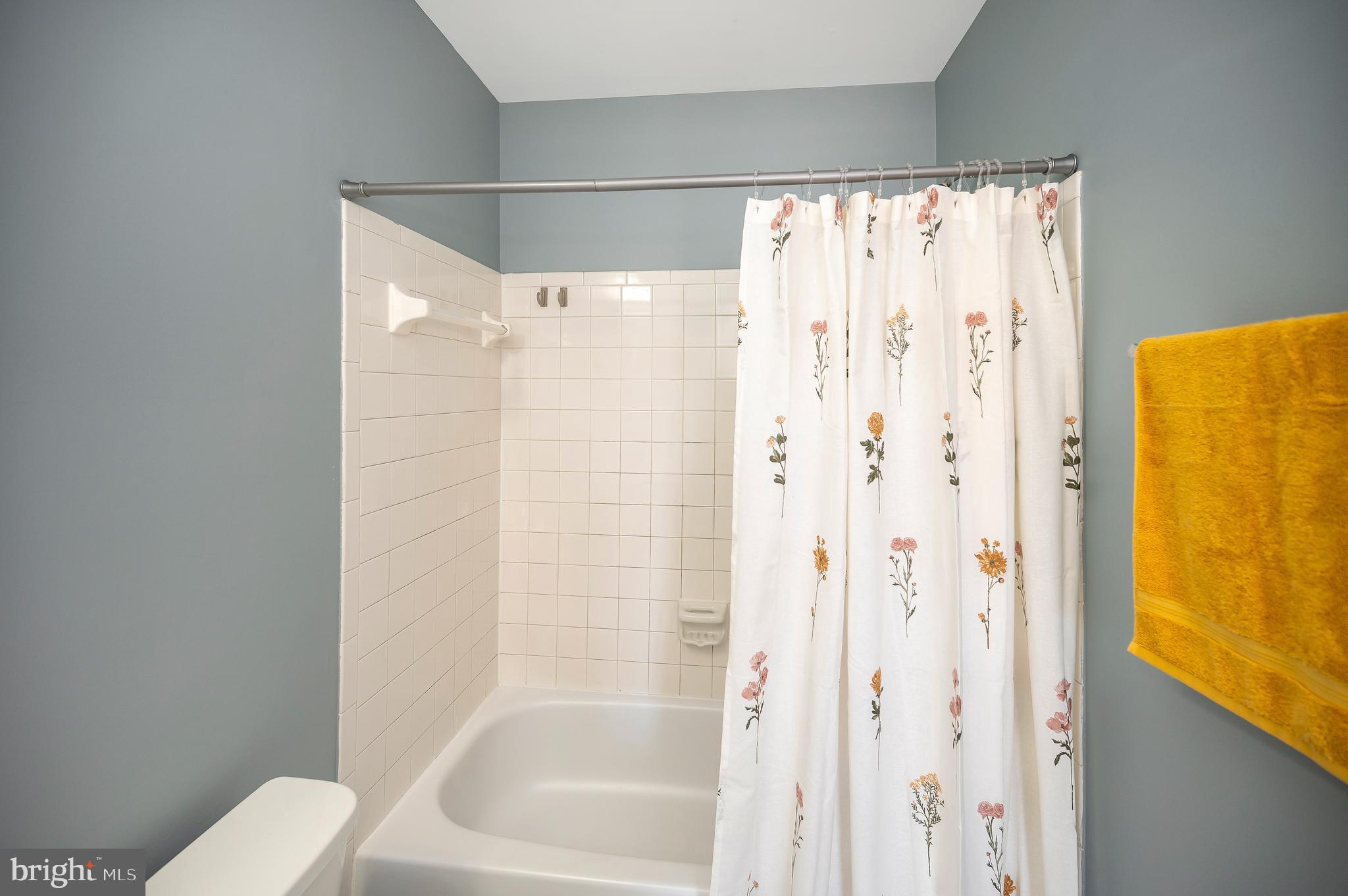17950 Milroy Drive Dumfries, VA 22026 - Photo 24 of 42 a bathroom with a shower curtain and a toilet