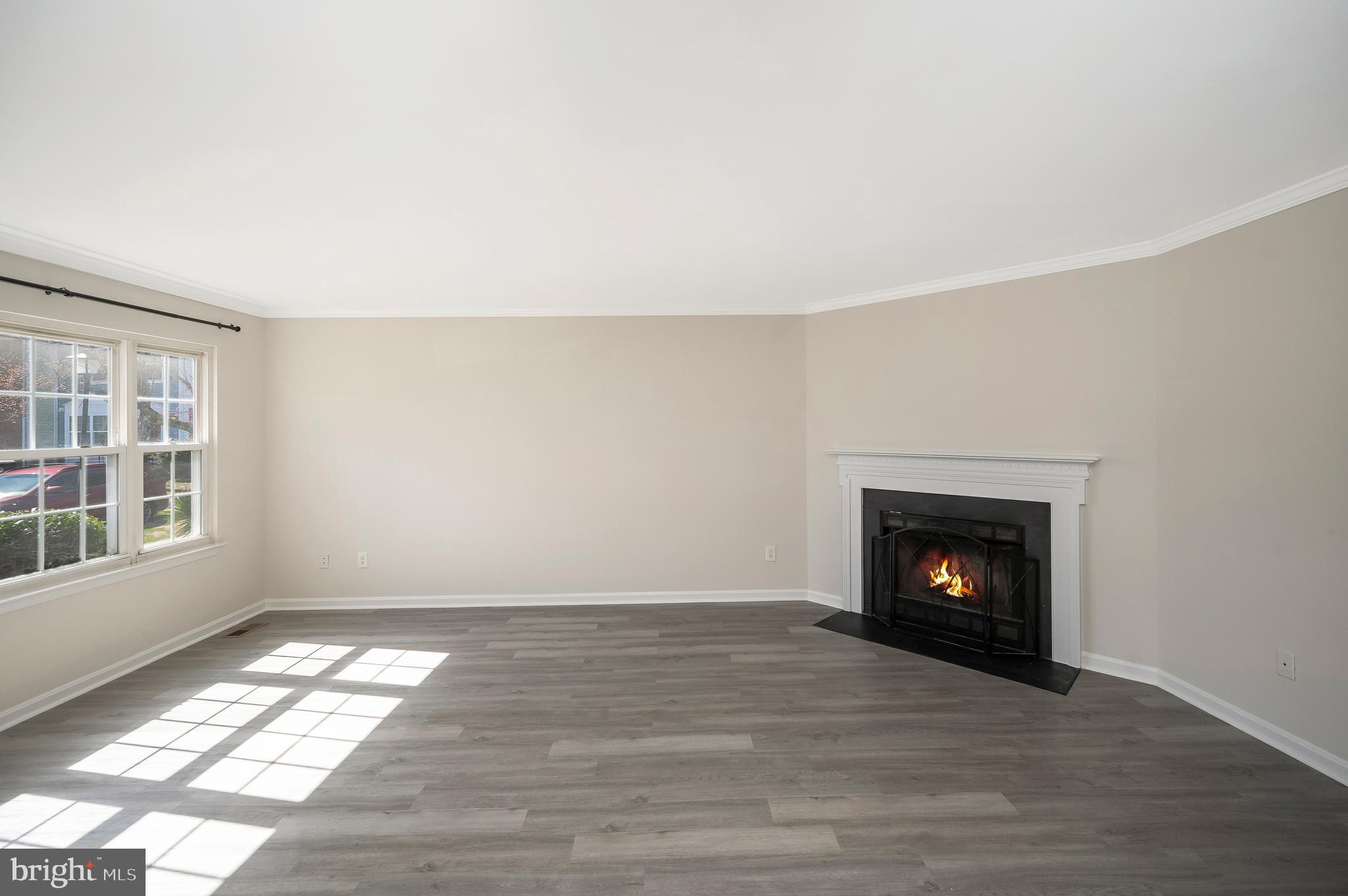 17950 Milroy Drive Dumfries, VA 22026 - Photo 9 of 42 an empty room with wooden floor fireplace and windows