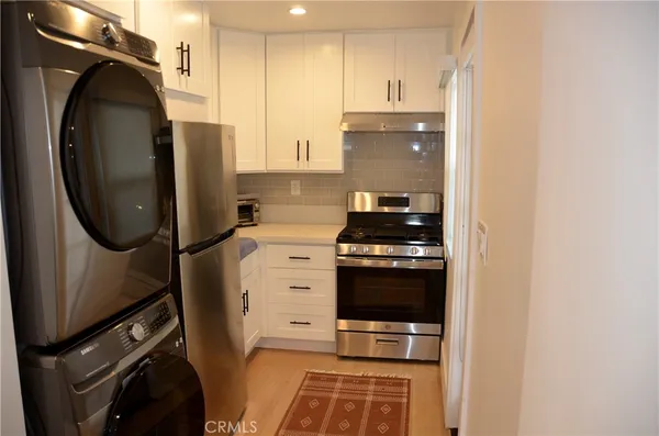 a kitchen with stainless steel appliances granite countertop a refrigerator and a stove