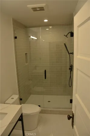 a bathroom with a shower a toilet and sink