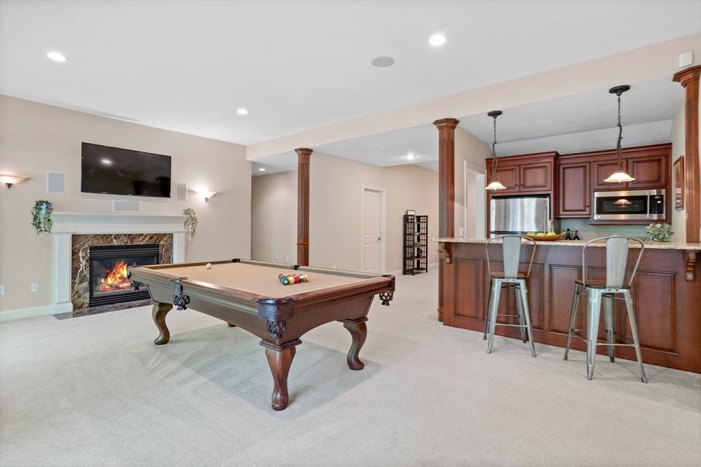 247 Whiley Road Groton, MA 01450 - Photo 31 of 42 a room with furniture a flat screen tv and a fireplace