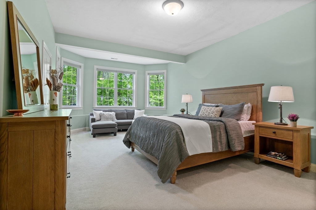 247 Whiley Road Groton, MA 01450 - Photo 34 of 42 a spacious bedroom with a bed and a couch next to a window