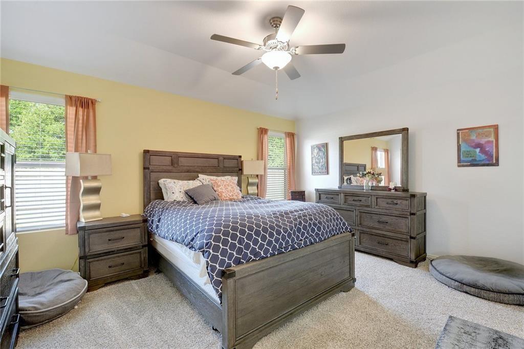6813 Colorado Bluffs Road Austin, TX 78744 - Photo 8 of 20 Bedroom featuring light carpet and a ceiling fan