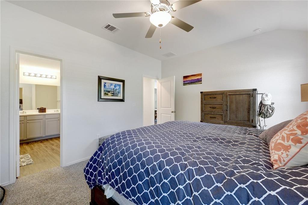 6813 Colorado Bluffs Road Austin, TX 78744 - Photo 9 of 20 Bedroom featuring light carpet, ceiling fan, and connected bathroom