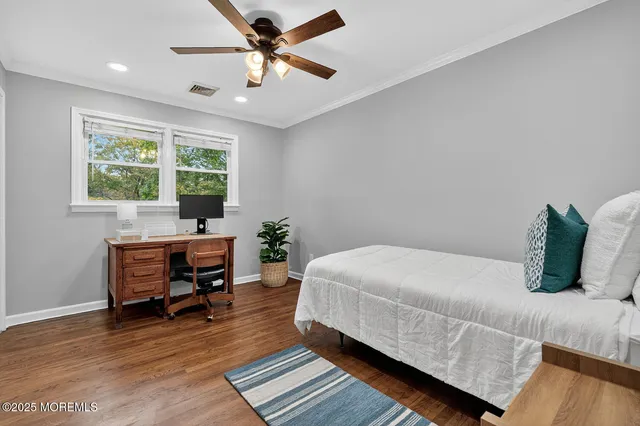 a bedroom with a bed a table and a potted plant