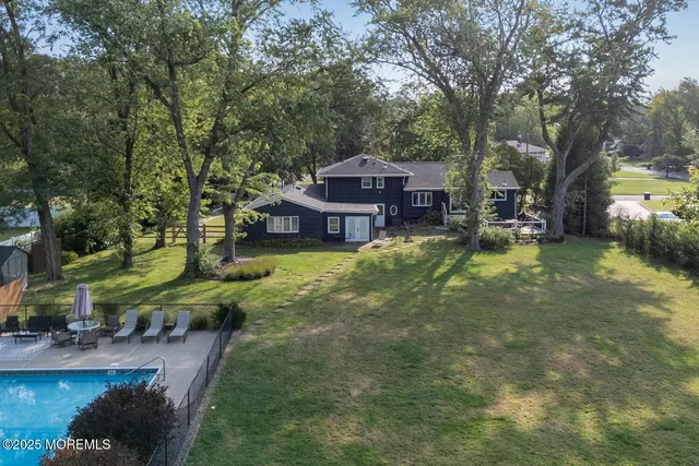 a view of a house with pool and sitting area