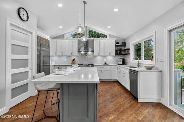 a kitchen with kitchen island granite countertop a sink cabinets and wooden floor
