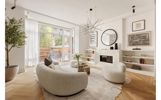 a living room with furniture a fireplace and a large window