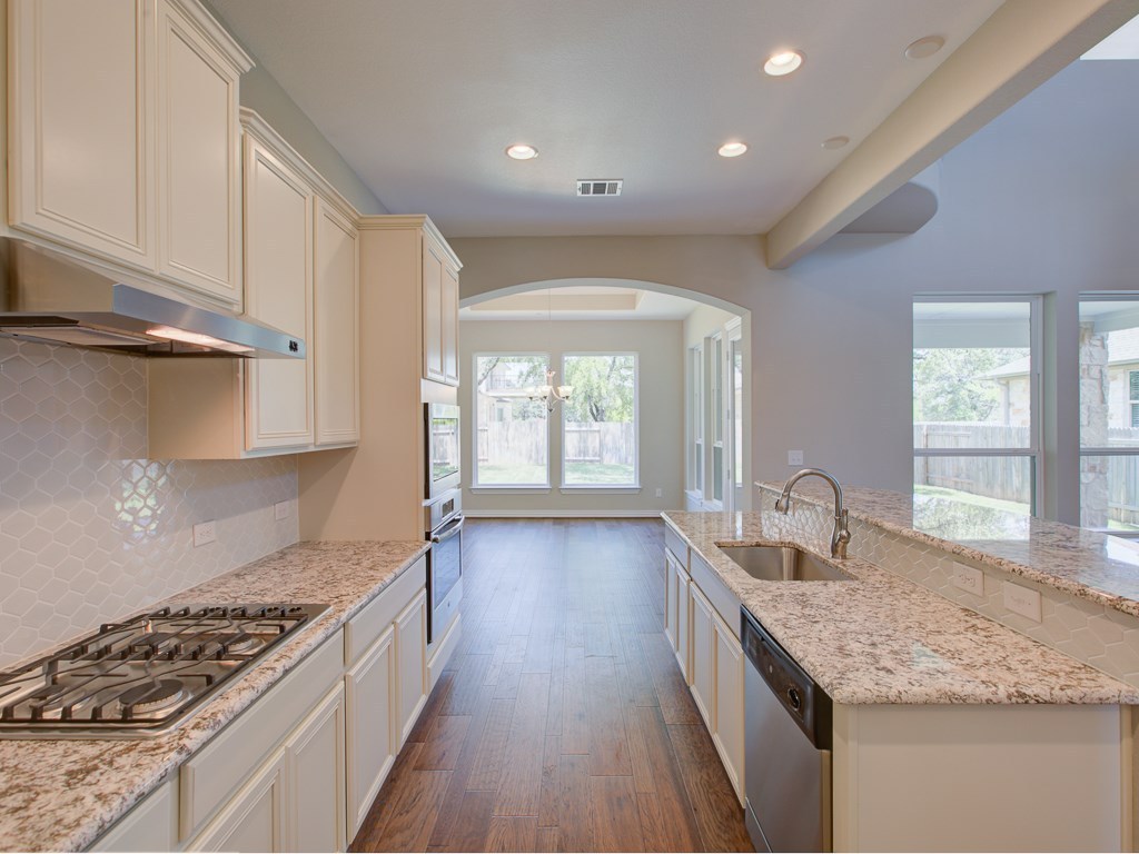 4303 Logan Ridge Drive Cedar Park, TX 78613 - Photo 4 of 24 Open-concept kitchen featuring extensive counter space, light-toned cabinetry, and stainless steel appliances including a gas range and built-in oven