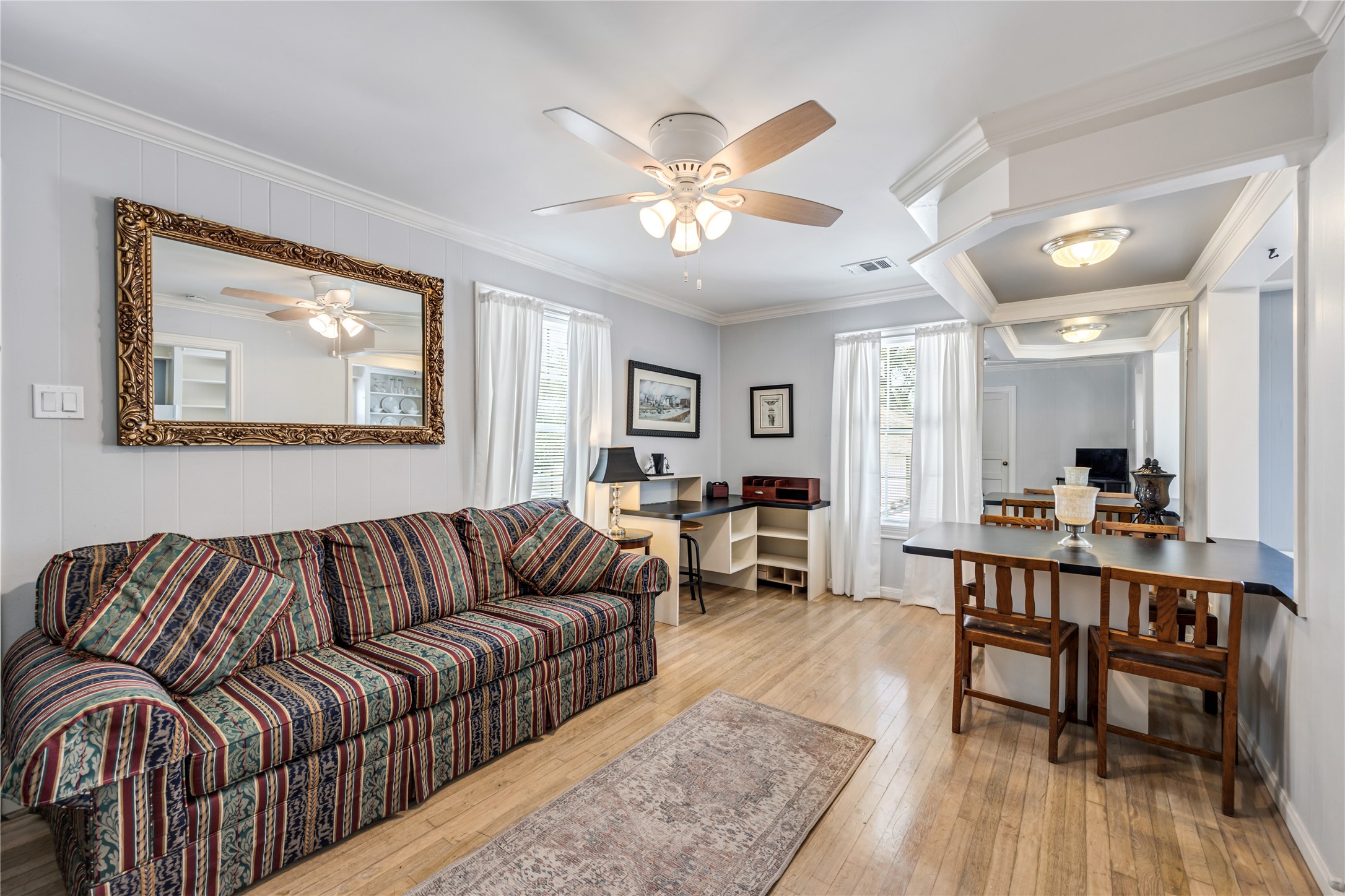 a living room with furniture and a wooden floor
