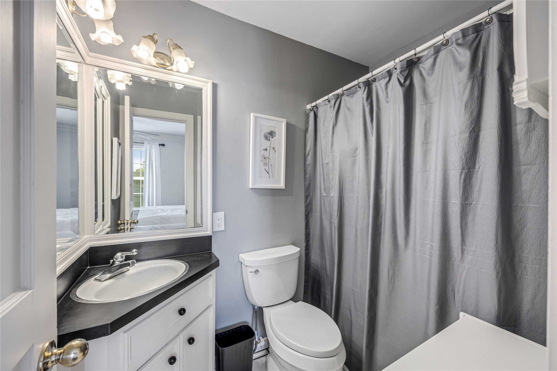1310 Reid Street, Unit B Houston, TX 77022 - Photo 10 of 13 a bathroom with a sink a toilet a mirror and shower curtain