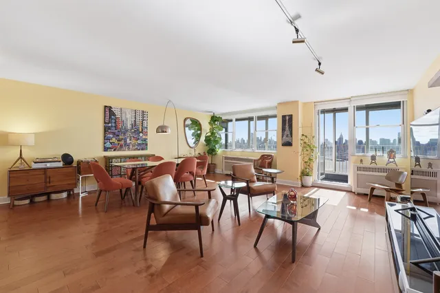 a living room with furniture wooden floor and a floor to ceiling window