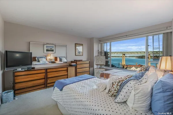 a bedroom with a bed and large windows