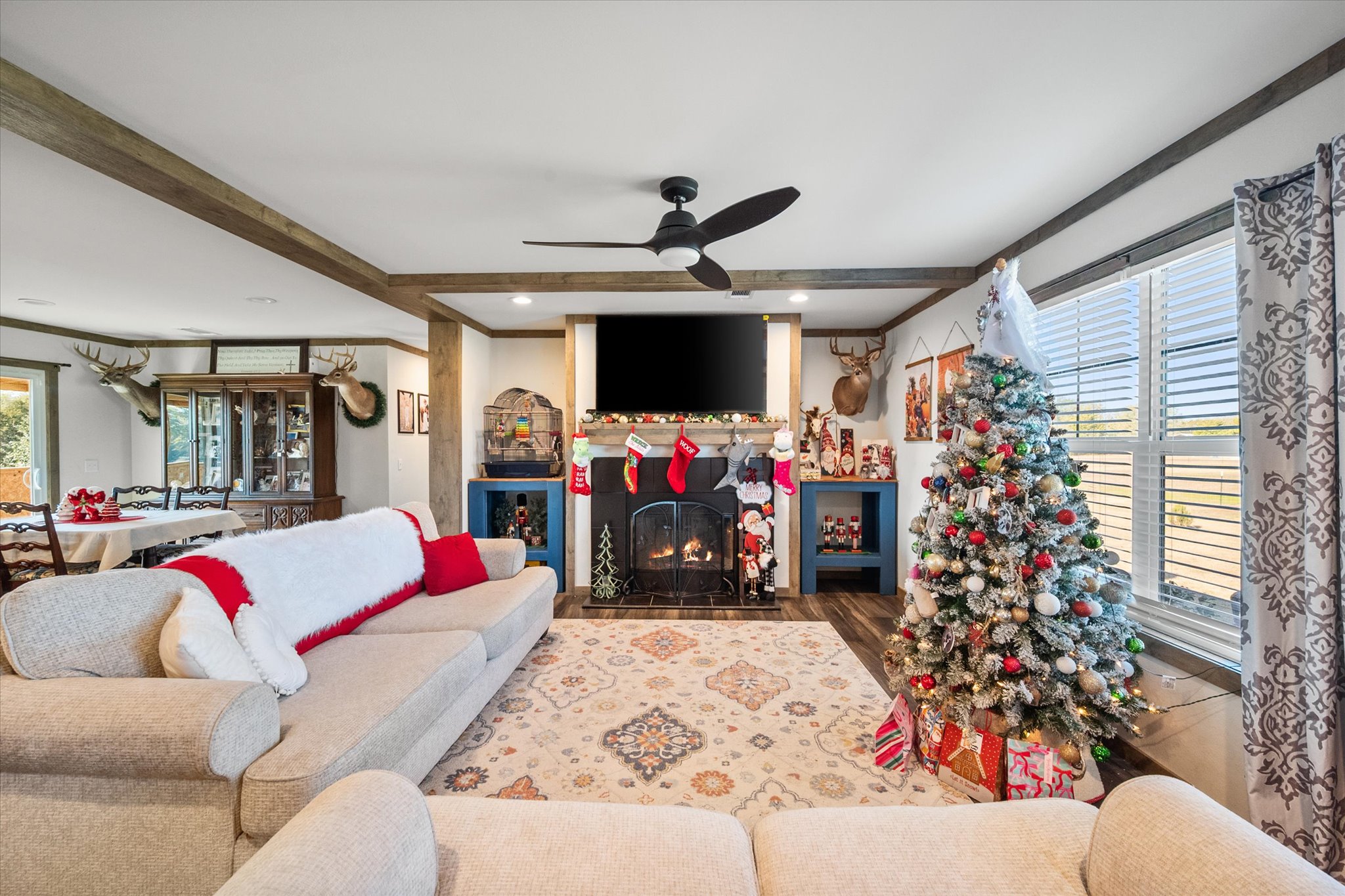 16857 Fm 639 Road East Purdon, TX 76679 - Photo 19 of 38 Living room with a fireplace with flush hearth, wood finished floors, beamed ceiling, ceiling fan, and ornamental molding