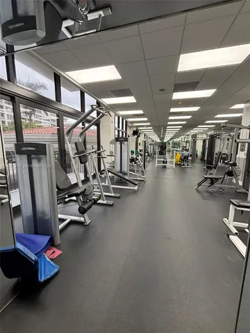 a dining room with furniture large windows and wooden floor