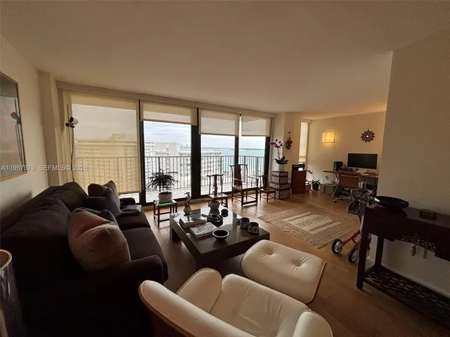 a living room with furniture and floor to ceiling windows