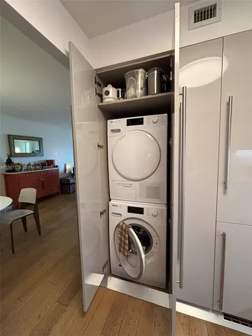 a utility room with wooden floor washer and dryer