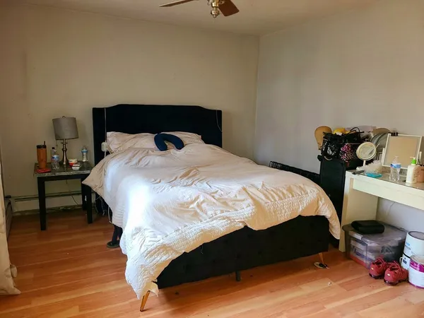 a bedroom with a bed and wooden floor