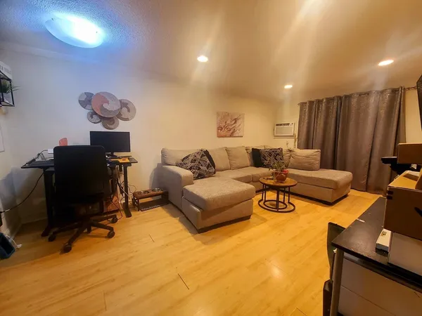 a living room with furniture a flat screen tv and a window