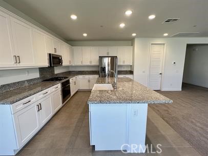 24800 Cimarron Circle Menifee, CA 92584 - Photo 9 of 29 a large kitchen with granite countertop a sink and white cabinets
