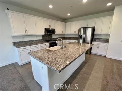 24800 Cimarron Circle Menifee, CA 92584 - Photo 10 of 29 a kitchen with stainless steel appliances granite countertop a sink stove and refrigerator