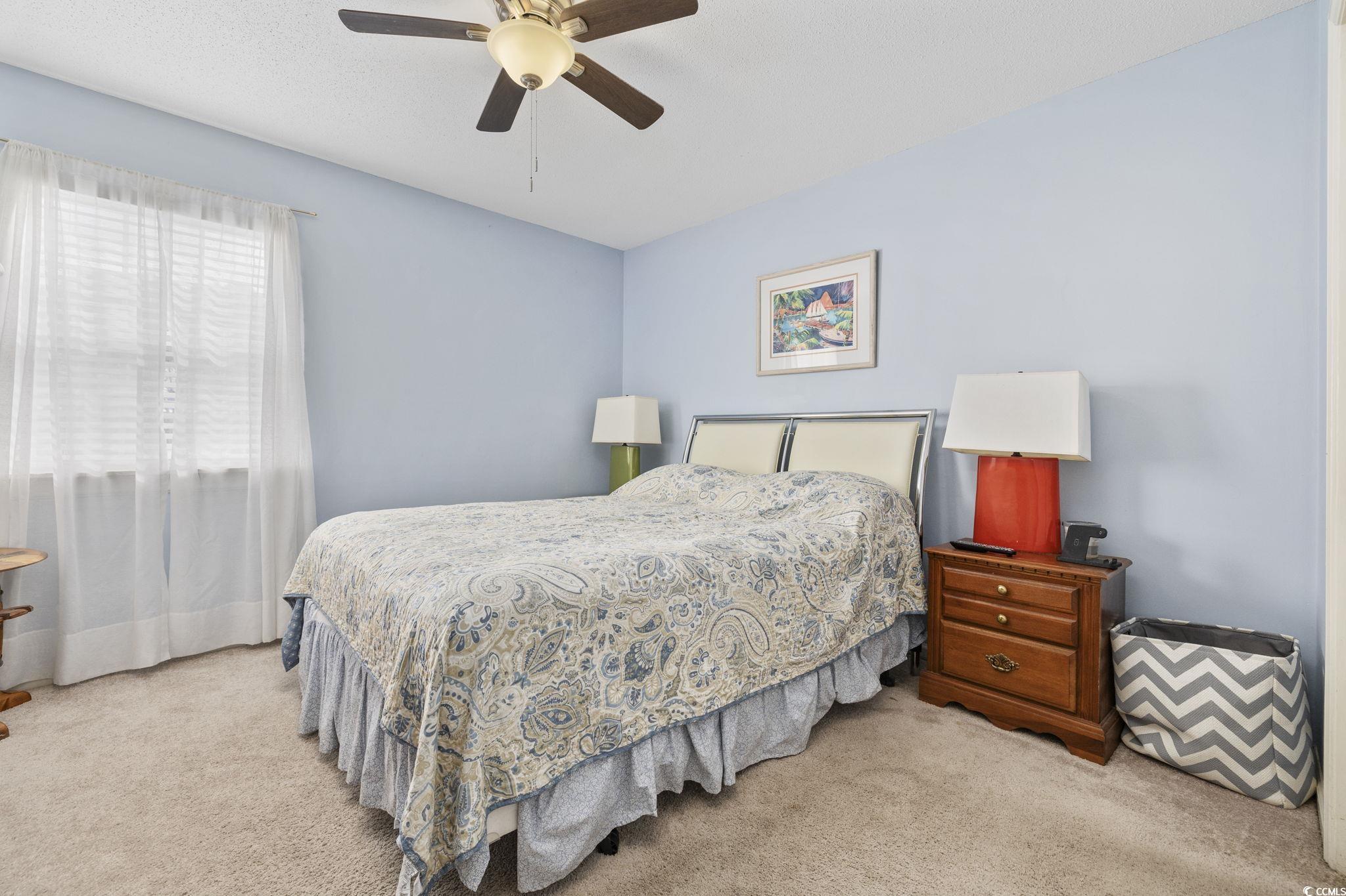 1356 Glenns Bay Road, Unit E 204 Surfside Beach, SC 29575 - Photo 14 of 27 Bedroom with light carpet and ceiling fan