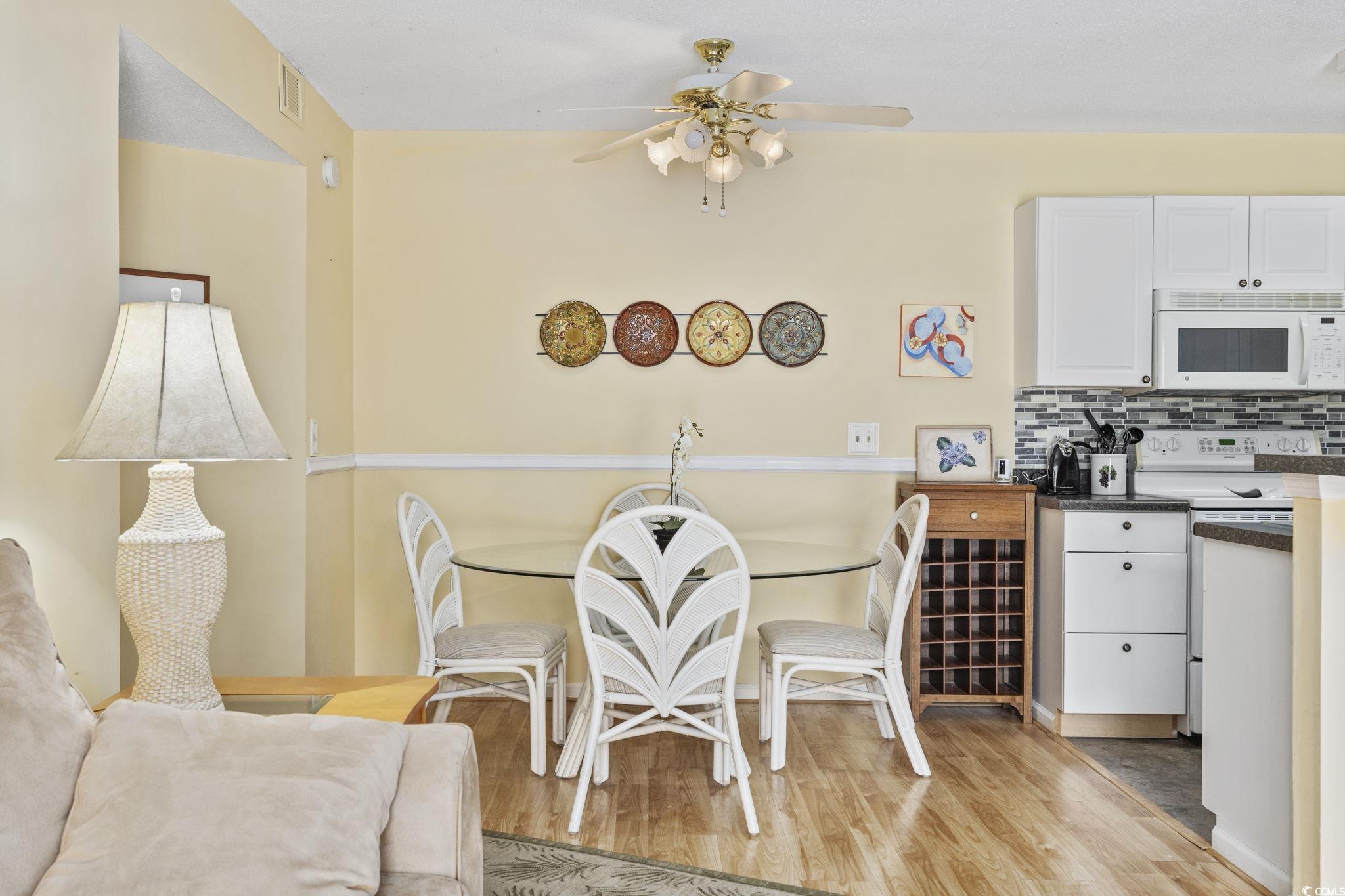 Dining room with ceiling fan and light wood-type f