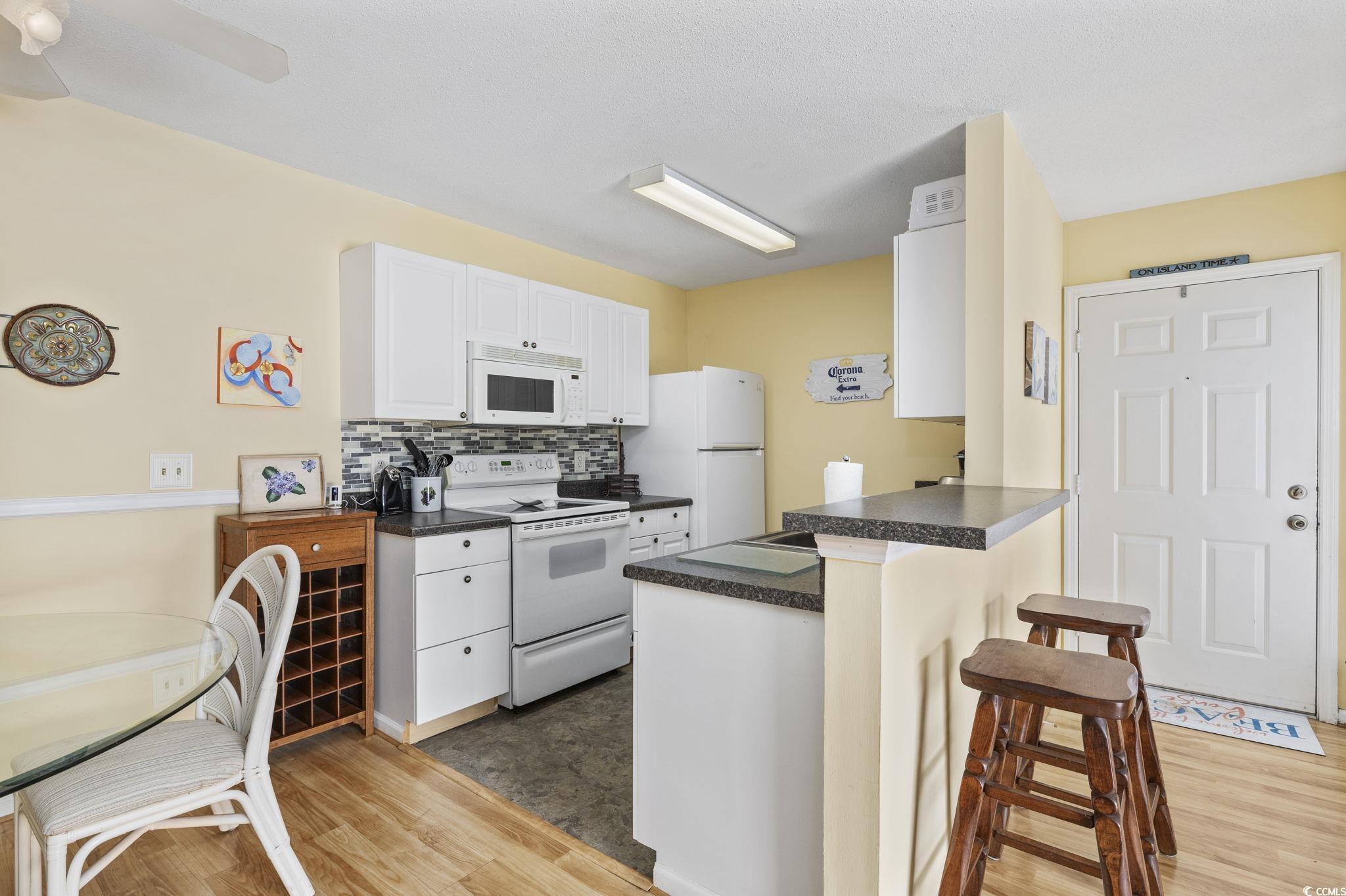 Kitchen featuring a breakfast bar, white cabinets,