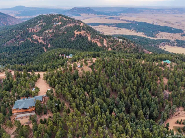 an aerial view of residential house with green space and mountain view