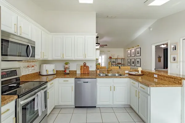a kitchen with a sink stove top oven and cabinets