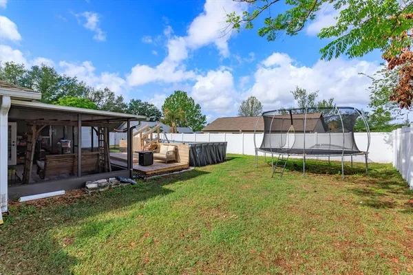 a backyard of a house with yard and trampoline