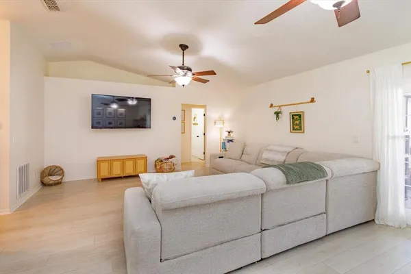 a living room with furniture a flat screen tv and a window