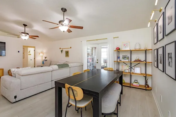 a living room with furniture a chandelier and a dining table
