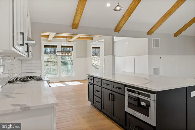 a view of an empty room with wooden floor fire place