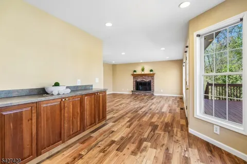 a view of a kitchen with kitchen island granite countertop a large window a sink and stainless steel appliances