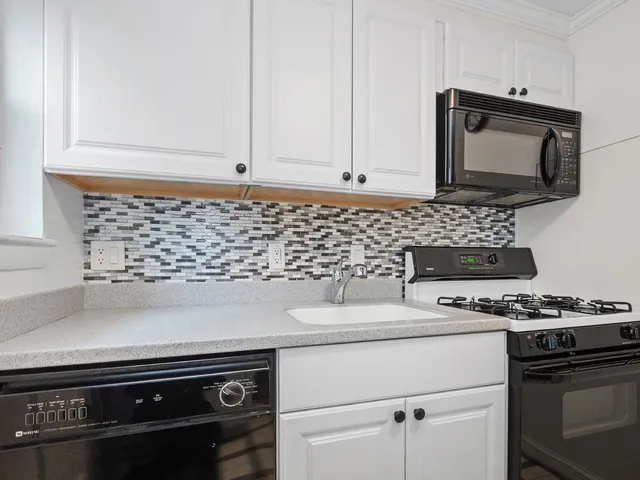 a kitchen with granite countertop a stove and a microwave