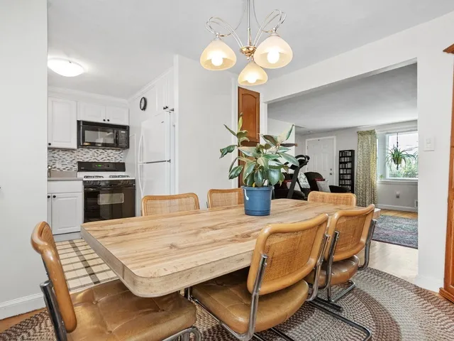 a dining room filled chandelier and kitchen view