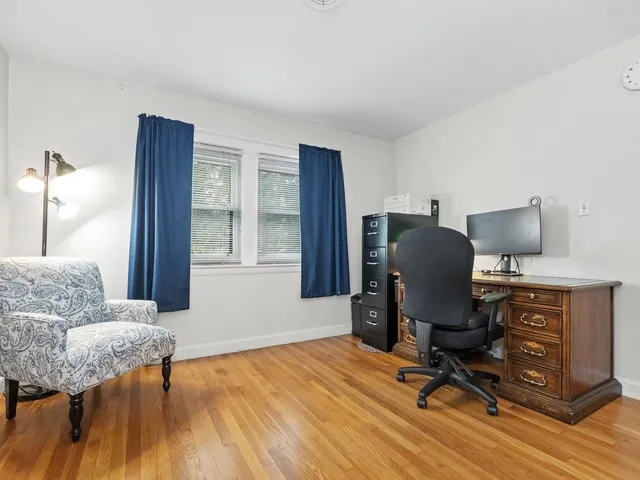 a view of a workspace with furniture and a window