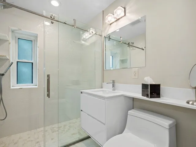 a bathroom with a toilet sink shower and mirror