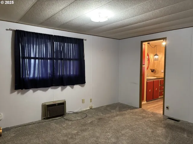 a view of an empty room and cabinet with wooden floor