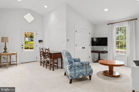 a living room with furniture a flat screen tv and a window