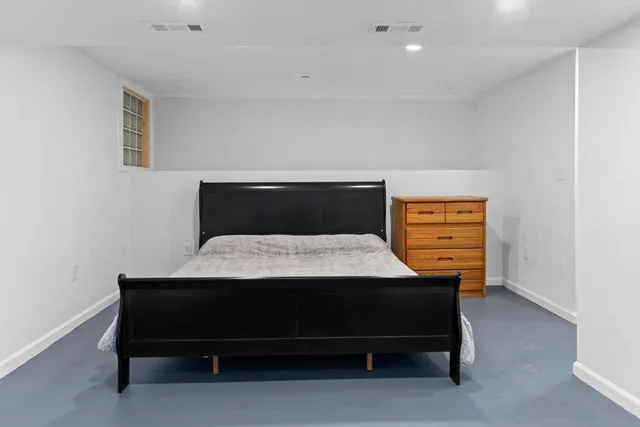 a bedroom with a bed and a lamp on desk