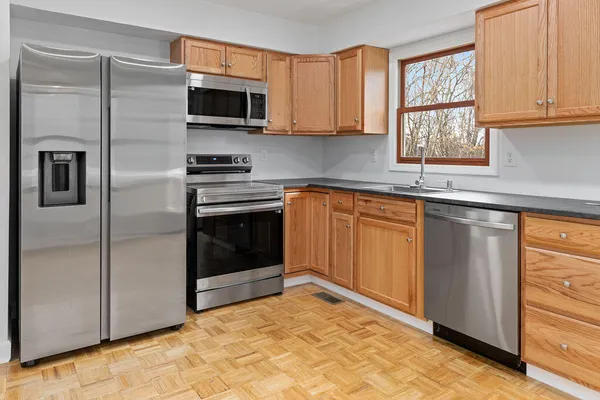 a kitchen with stainless steel appliances granite countertop a stove microwave and refrigerator
