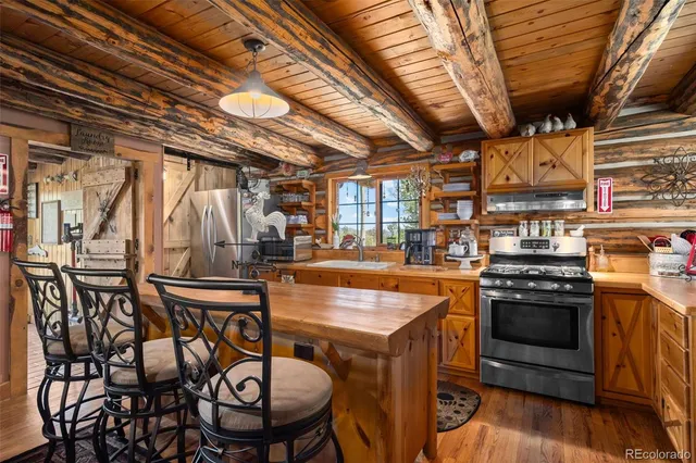 a room with stainless steel appliances kitchen island granite countertop lots of counter top space