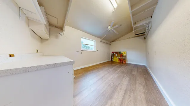 a view of empty room with wooden floor and windows