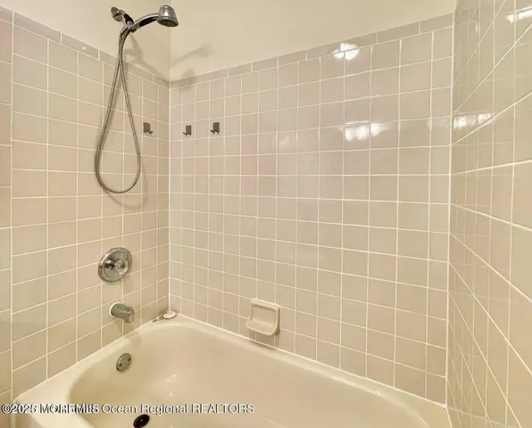 a bathroom with a bath tub with a shower