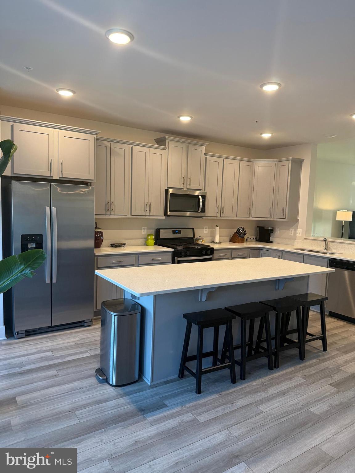 2932 Osprey Way North Frederick, MD 21701 - Photo 5 of 42 a kitchen with stainless steel appliances granite countertop a table chairs refrigerator microwave and cabinets