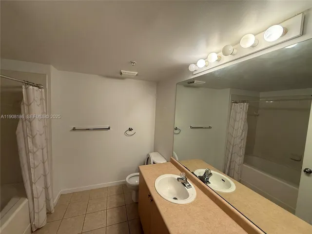 a bathroom with a sink a toilet a mirror and shower