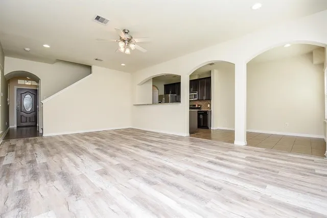 a view of a livingroom with wooden floor and a ceiling fan